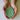 Green ceramic leaf-shaped object held in hands against a plain background
